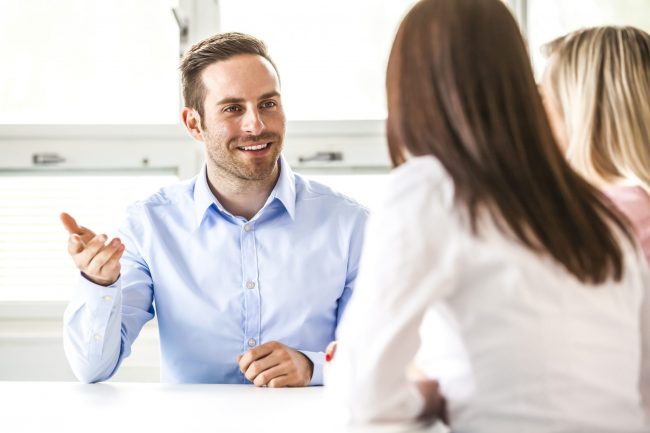 Young businessman discussing with female colleagues in board room
